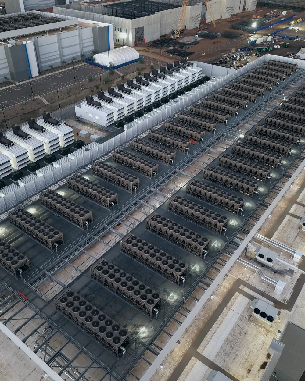 Rows of cooling units and generators on the roof and yard of a large data center